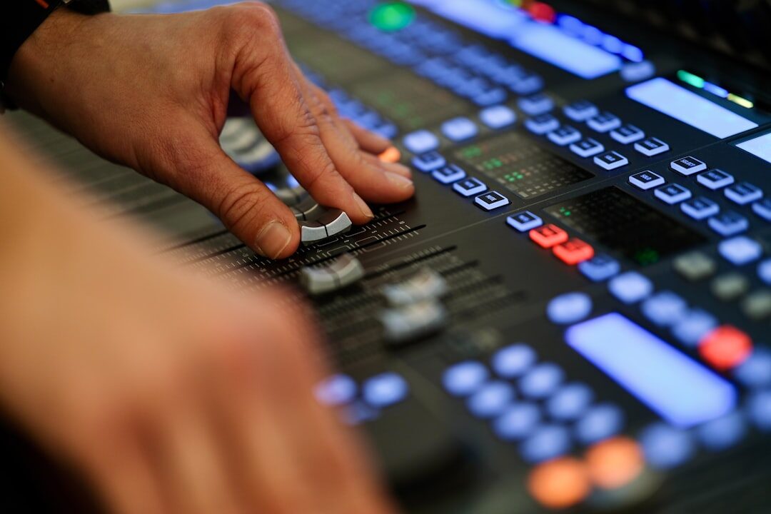 Broadcast technician monitoring a multi-camera video switcher in a control room
